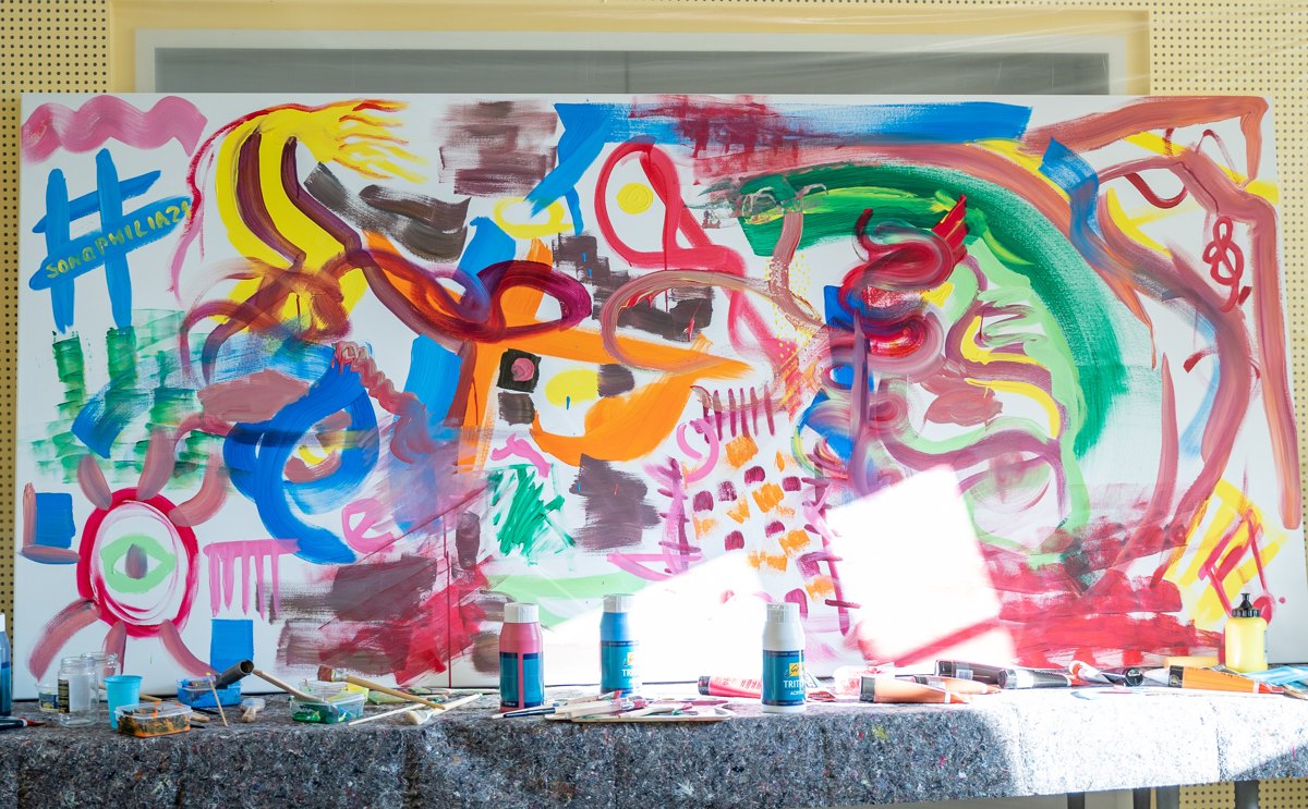 A colourful collaborative painting and art materials at the 2021 Sonophilia Creative Leadership Forum.