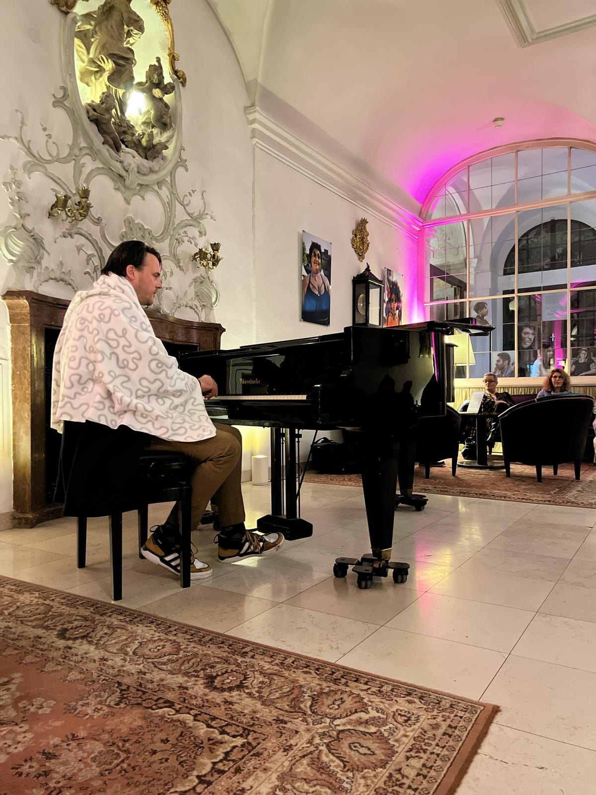 A pianist playing a grand piano during the 2023 Sonophilia Annual Meeting.